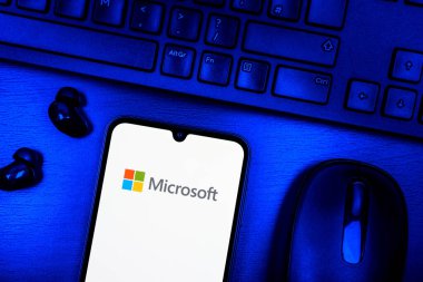 Prag, Çek Cumhuriyeti - 08 09 2025: Microsoft logosunu gösteren bir telefonun olduğu bir masanın yukarıdan görünüşü. Microsoft yazılım, donanım ve hizmet sunan bir teknoloji şirketidir..