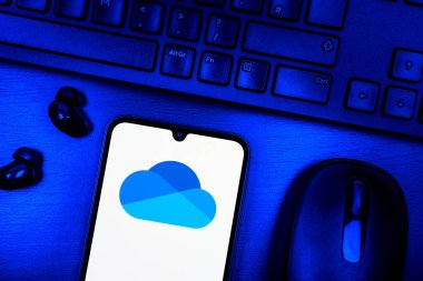 Prag, Çek Cumhuriyeti - 08 09 2025: OneDrive logosunu gösteren bir telefonun olduğu bir masanın yukarıdan görünüşü. OneDrive dosyaları kaydetmek ve paylaşmak için bir bulut depolama platformudur.