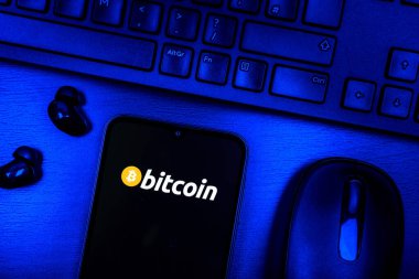 Prag, Çek Cumhuriyeti - 08 09 2025: Bitcoin logosunu gösteren bir telefonun olduğu bir masanın yukarıdan görünüşü. Bitcoin merkezi olmayan işlemler için dijital bir kripto para birimidir.