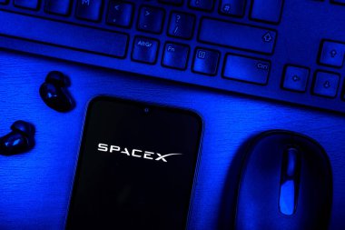 Prague, Czechia - 08 09 2025: A top-down view of a desk with a phone displaying the SpaceX logo. SpaceX is a private company for space exploration and rocket launches.