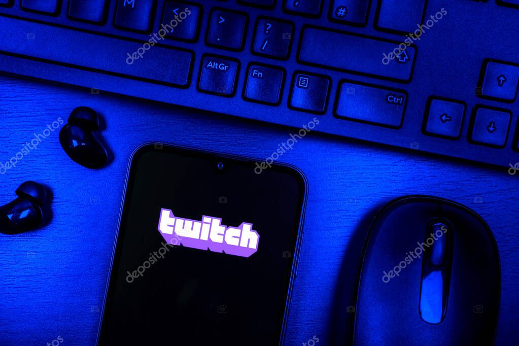 Prague, Czechia - 08 09 2025: A top-down view of a desk with a phone displaying the Twitch logo. Twitch is a platform for live streaming games and content.