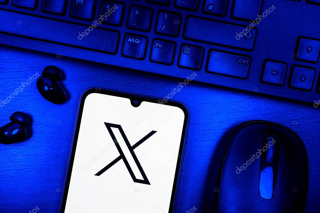 Prague, Czechia - 08 09 2025: A top-down view of a desk with a phone displaying the X logo. X is a platform for sharing short posts and updates.