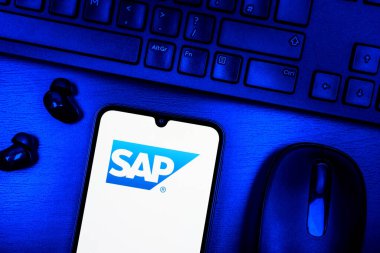 Prague, Czechia - 08 09 2025: A top-down view of a desk with a phone displaying the SAP logo. SAP is a software company providing enterprise applications and solutions.
