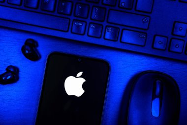 Prague, Czechia - 08 09 2025: A top-down view of a desk with a phone displaying the Apple logo. Apple is a technology company making iPhones, computers, and services.