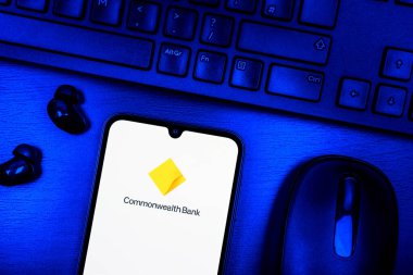 Prague, Czechia - 08 09 2025: A top-down view of a desk with a phone displaying the Commonwealth Bank logo. Commonwealth Bank is a bank providing financial services in Australia.