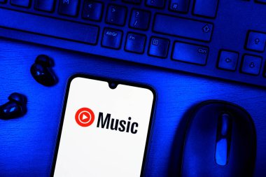 Prague, Czechia - 08 09 2025: A top-down view of a desk with a phone displaying the Youtube Music logo. Youtube Music is a platform for streaming and discovering music.