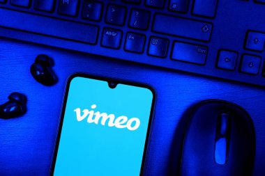 Prague, Czechia - 08 09 2025: A top-down view of a desk with a phone displaying the Vimeo logo. Vimeo is a platform for hosting and sharing high-quality videos.
