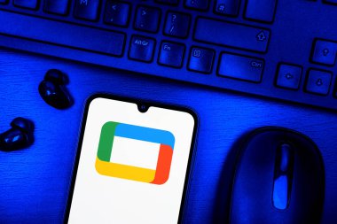 Prague, Czechia - 08 09 2025: A top-down view of a desk with a phone displaying the Google TV logo. Google TV is a platform for streaming movies, shows, and apps.