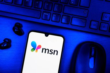 Prague, Czechia - 08 09 2025: A top-down view of a desk with a phone displaying the MSN logo. MSN is a platform for news, email, and online services.