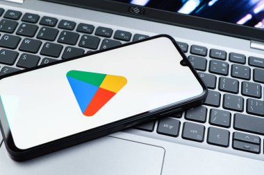Prag, Çek Cumhuriyeti - 08 01 2025: Dizüstü bilgisayarda bulunan bir cep telefonu Google Play logosunu görüntüler. Google Play uygulamaları, oyunları ve dijital içeriği indirmek için bir platformdur.