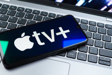 Prag, Çek Cumhuriyeti - 08 01 2025: Laptop klavyesinde uzanan bir cep telefonu Apple TV + logosunu gösteriyor. Apple TV +, filmler ve TV programları için bir yayın platformudur..