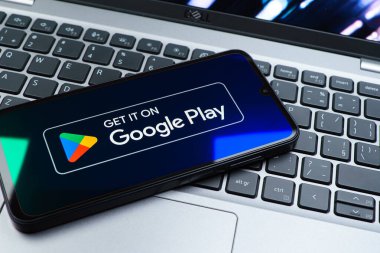 Prag, Çek Cumhuriyeti - 08 01 2025: Dizüstü bilgisayarda bulunan bir cep telefonu Google Play logosunu görüntüler. Google Play uygulamaları, oyunları ve dijital içeriği indirmek için bir platformdur.