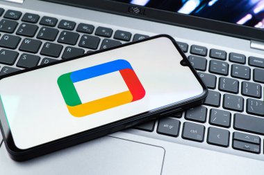 Prag, Çek Cumhuriyeti - 08 01 2025: Laptop klavyesinde uzanan bir cep telefonu Google TV logosunu gösteriyor. Google TV film, program ve uygulamalar için bir platformdur..
