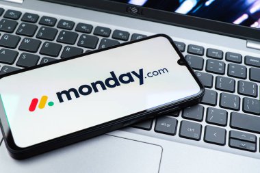 Prag, Çek Cumhuriyeti - 08 01 2025: Laptop klavyesinde duran bir cep telefonu Monday.com logosunu gösteriyor. Monday.com proje yönetimi ve takım işbirliği için bir platformdur.