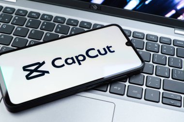 Prag, Çek Cumhuriyeti - 08 01 2025: Laptop klavyesinde duran bir cep telefonu CapCut logosunu gösteriyor. CapCut video düzenleme ve oluşturma için bir platformdur.