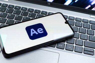 Prag, Çek Cumhuriyeti - 08 01 2025: Laptop klavyesinde duran bir cep telefonu After Effects logosunu görüntüler. After Effects hareket grafikleri ve görsel efektler için bir yazılımdır..