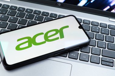 Prag, Çek Cumhuriyeti - 08 01 2025: Dizüstü bilgisayarın üzerinde duran bir cep telefonu Acer logosunu gösterir. Acer bilgisayar ve elektronik üreten bir teknoloji şirketidir..