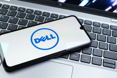 Prag, Çek Cumhuriyeti - 08 01 2025: Dizüstü bilgisayarın üzerinde duran bir cep telefonu Dell logosunu gösteriyor. Dell bilgisayar ve bilişim çözümleri üreten bir teknoloji şirketidir..