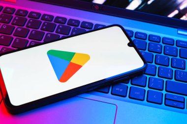 Prag, Çek Cumhuriyeti - 08 01 2025: Dizüstü bilgisayarda bulunan bir cep telefonu Google Play logosunu görüntüler. Google Play uygulamaları, oyunları ve dijital içeriği indirmek için bir platformdur.