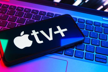 Prag, Çek Cumhuriyeti - 08 01 2025: Laptop klavyesinde uzanan bir cep telefonu Apple TV + logosunu gösteriyor. Apple TV +, filmler ve TV programları için bir yayın platformudur..