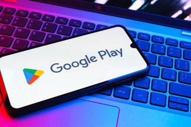 Prag, Çek Cumhuriyeti - 08 01 2025: Dizüstü bilgisayarda bulunan bir cep telefonu Google Play logosunu görüntüler. Google Play uygulamaları, oyunları ve dijital içeriği indirmek için bir platformdur.