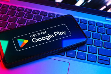 Prag, Çek Cumhuriyeti - 08 01 2025: Dizüstü bilgisayarda bulunan bir cep telefonu Google Play logosunu görüntüler. Google Play uygulamaları, oyunları ve dijital içeriği indirmek için bir platformdur.