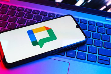 Prag, Çek Cumhuriyeti - 08 01 2025: Dizüstü bilgisayarın üzerinde duran bir cep telefonu Google Chat logosunu görüntüler. Google Chat mesajlaşma ve takım işbirliği için bir platformdur.