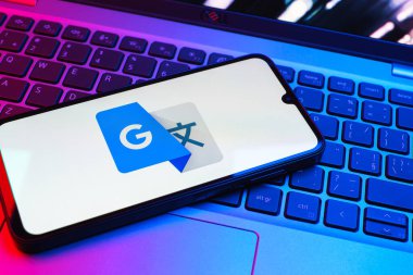 Prag, Çek Cumhuriyeti - 08 01 2025: Dizüstü bilgisayarda bulunan bir cep telefonu Google Translate logosunu görüntüler. Google Çevirisi metni ve konuşmayı diller arası çevirmek için bir platformdur..