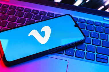 Prag, Çek Cumhuriyeti - 08 01 2025: Dizüstü bilgisayarın üzerinde duran bir cep telefonu Vimeo logosunu gösterir. Vimeo, yüksek kaliteli video sunucu ve paylaşımı için bir platformdur.