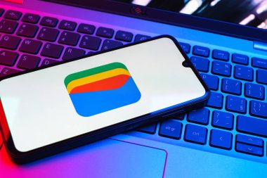 Prag, Çek Cumhuriyeti - 08 01 2025: Dizüstü bilgisayarda bulunan bir cep telefonu Google Cüzdan logosunu görüntüler. Google Cüzdanı dijital ödeme yöntemlerini depolamak ve kullanmak için bir platformdur.