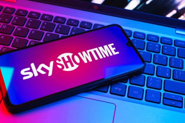Prag, Çek Cumhuriyeti - 08 01 2025: Dizüstü bilgisayarın üzerinde duran bir cep telefonu SkyShowtime logosunu gösteriyor. SkyShowtime, sinema ve televizyon dizileri için bir yayın platformudur..