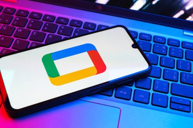 Prag, Çek Cumhuriyeti - 08 01 2025: Laptop klavyesinde uzanan bir cep telefonu Google TV logosunu gösteriyor. Google TV film, program ve uygulamalar için bir platformdur..