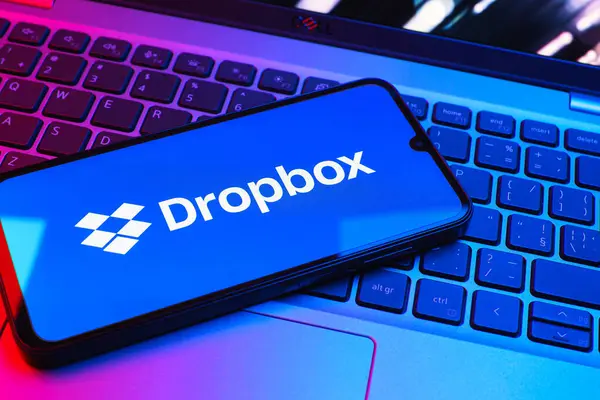 Prag, Çek Cumhuriyeti - 08 01 2025: Laptop klavyesinde duran bir cep telefonu Dropbox logosunu gösterir. Dropbox bulut depolama ve dosya paylaşımı için bir platformdur.