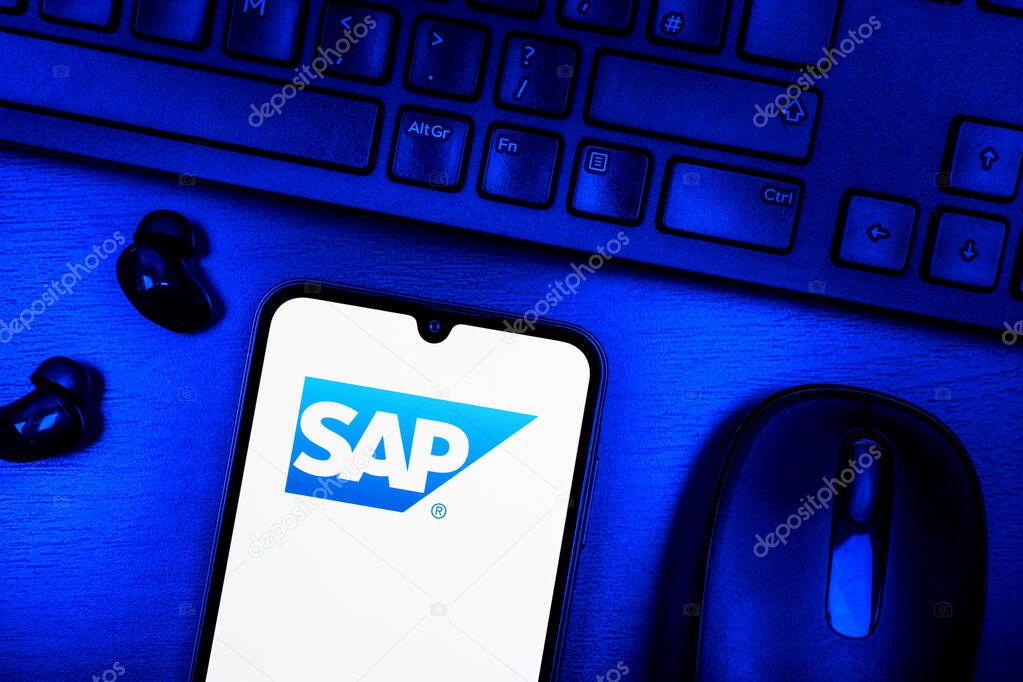 Prague, Czechia - 08 09 2025: A top-down view of a desk with a phone displaying the SAP logo. SAP is a software company providing enterprise applications and solutions.