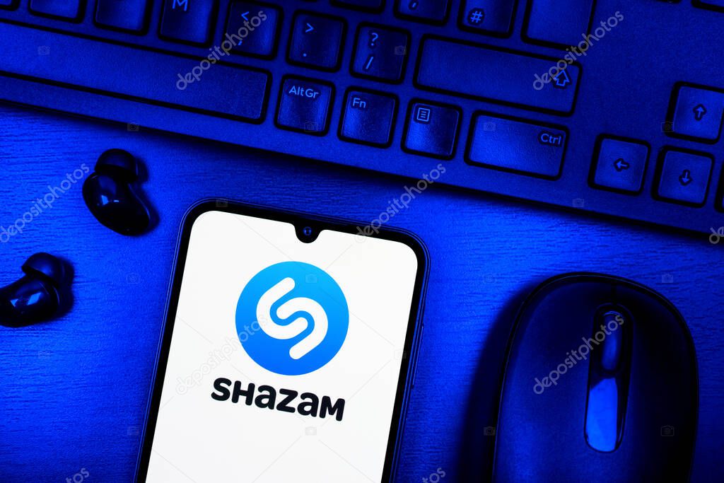 Prague, Czechia - 08 09 2025: A top-down view of a desk with a phone displaying the Shazam logo. Shazam is an app for identifying songs and music tracks.
