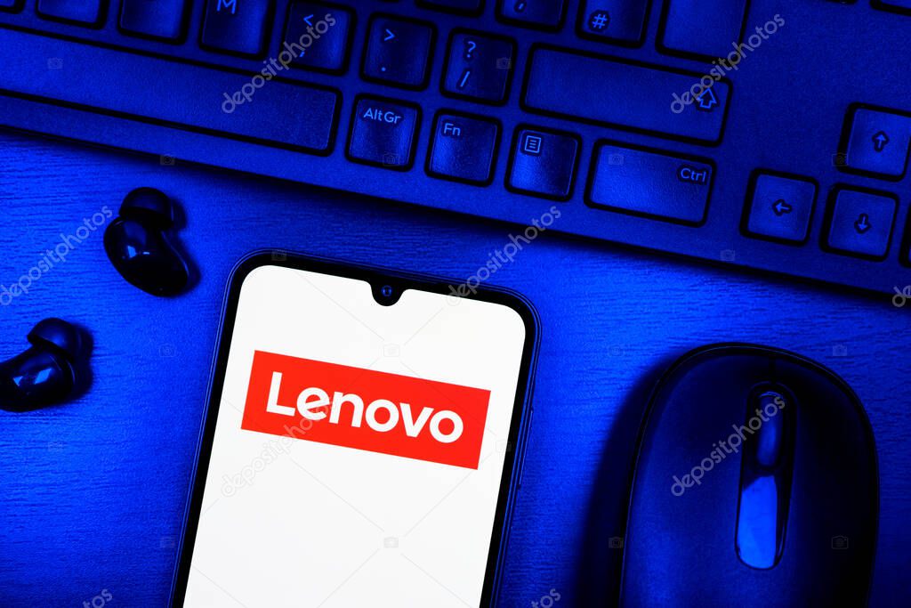 Prague, Czechia - 08 09 2025: A top-down view of a desk with a phone displaying the Lenovo logo. Lenovo is a technology company producing computers and electronics.