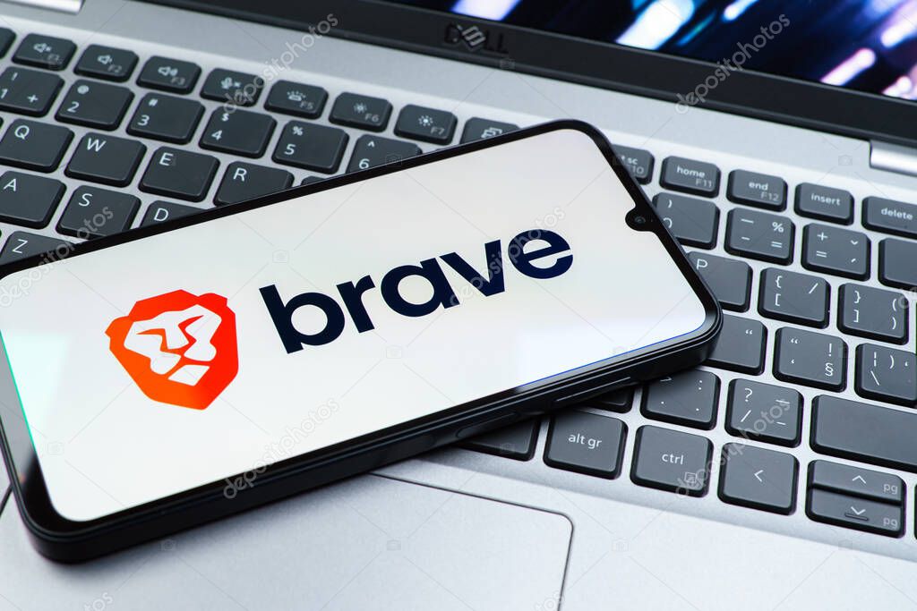 Prague, Czechia - 08 01 2025: A mobile phone lying on a laptop keyboard displays the Brave logo. Brave is a web browser focused on privacy and speed.
