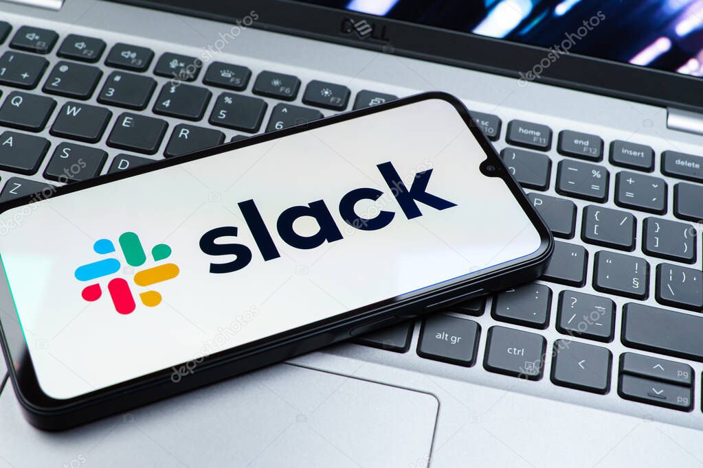 Prague, Czechia - 08 01 2025: A mobile phone lying on a laptop keyboard displays the Slack logo. Slack is a platform for team messaging and workplace communication.