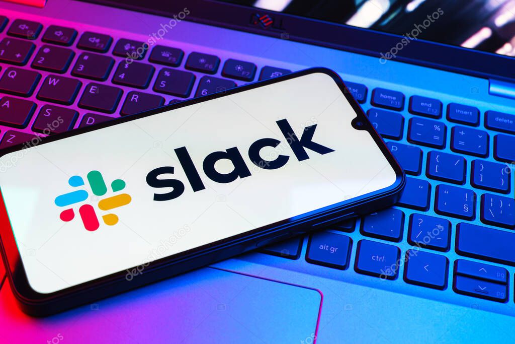 Prague, Czechia - 08 01 2025: A mobile phone lying on a laptop keyboard displays the Slack logo. Slack is a platform for team messaging and workplace communication.