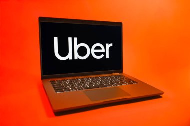 Prag, Çek Cumhuriyeti - 08 01 2025: Üniforma arka planda bir dizüstü bilgisayar Uber logosunu gösteriyor. Uber ulaşım ve dağıtım hizmetleri için bir gezinti selamlama uygulaması.