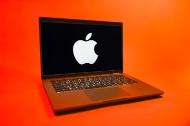 Prag, Çek Cumhuriyeti - 08 01 2025: Uniforma arka planda bir dizüstü bilgisayar Apple logosunu gösterir. Apple iPhone, bilgisayar ve hizmet üreten bir teknoloji şirketidir..