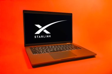 Prag, Çek Cumhuriyeti - 08 01 2025: Tek bir arkaplanda bir dizüstü bilgisayar Starlink logosunu gösterir. Starlink küresel bağlantı sağlayan bir uydu internet hizmetidir.