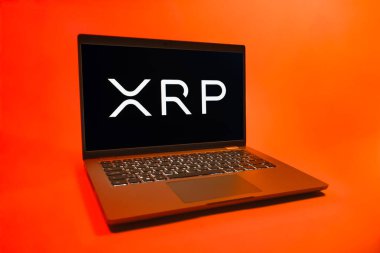 Prag, Çek Cumhuriyeti - 08 01 2025: Tek tip arkaplanda bir dizüstü bilgisayar Ripple logosunu gösterir. Dalgalanma dijital kripto para birimi ve ödeme protokolüdür..