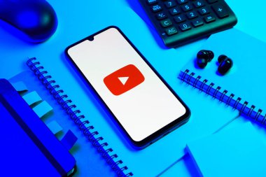Prag, Çek Cumhuriyeti - 08 18 2025: Merkezde Youtube logosu sergilenen bir cep telefonu ile ofis malzemeleri düzenlemesi. Youtube dünya çapında videoları izlemek ve paylaşmak için bir platform.