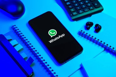 Prag, Çek Cumhuriyeti - 08 18 2025: Ofis malzemelerinin merkezde WhatsApp logosunu gösteren bir cep telefonu ile düzenlenmesi. WhatsApp mesaj, çağrı ve medya göndermek için bir uygulamadır.