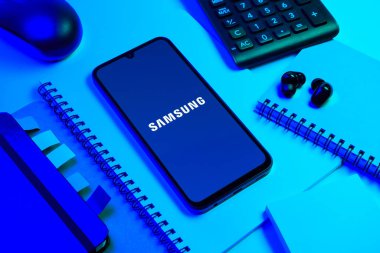 Prag, Çek Cumhuriyeti - 08 18 2025: Merkezde Samsung logosu sergilenen bir cep telefonu ile ofis malzemeleri düzenlemesi. Samsung elektronik ve cihaz üreten bir teknoloji şirketi..
