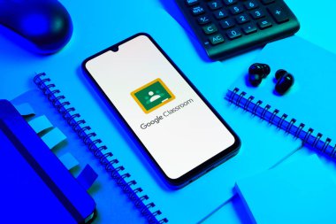 Prag, Çek Cumhuriyeti - 08 18 2025: Merkezde Google Sınıfı logosunu gösteren bir cep telefonu ile ofis malzemeleri düzenlemesi. Google Sınıfı, sınıfları ve eğitim içeriğini yönetmek için bir platformdur.