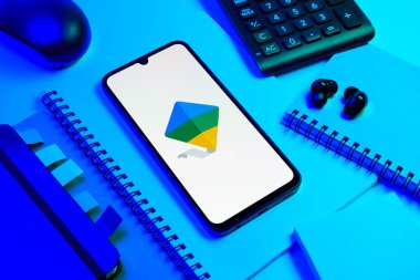 Prag, Çek Cumhuriyeti - 08 18 2025: Merkezde Google Family Link logosunu gösteren bir cep telefonu ile ofis malzemeleri düzenlemesi. Google Family Link ebeveyn denetimi ve çocuk hesabı yönetimi için bir platformdur.