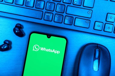Prag, Çek Cumhuriyeti - 08 09 2025: WhatsApp logosunu gösteren bir telefonun olduğu bir masanın yukarıdan görünüşü. WhatsApp mesaj, çağrı ve medya göndermek için bir uygulamadır.