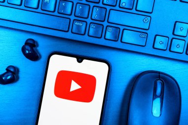 Prag, Çek Cumhuriyeti - 08 09 2025: Youtube logosunu gösteren bir telefonun olduğu bir masanın yukarıdan görünüşü. Youtube dünya çapında videoları izlemek ve paylaşmak için bir platform.